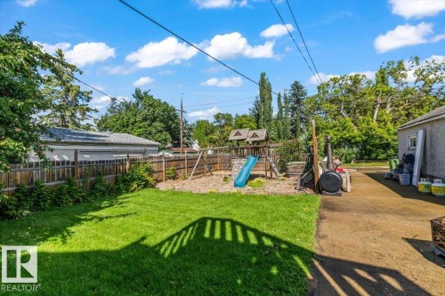 Expansive grassy yard with wood fencing and mature perimeter trees - 11429 64 Street Nw, Edmonton, AB - Outdoor With Backyard