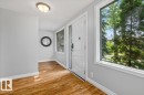 Wood-finish flooring, white trim, and a white front door with sidelights - 11429 64 Street Nw, Edmonton, AB  - Indoor Photo Showing Other Room 