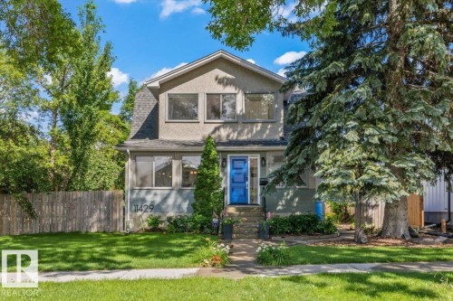 Two-story stucco exterior with a prominent blue entry door, gabled roofline, and established front yard landscaping - 11429 64 Street Nw, Edmonton, AB - Outdoor