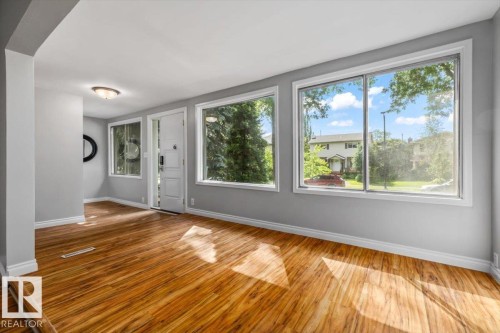 Wood-finish flooring throughout the space - 11429 64 Street Nw, Edmonton, AB - Indoor Photo Showing Other Room