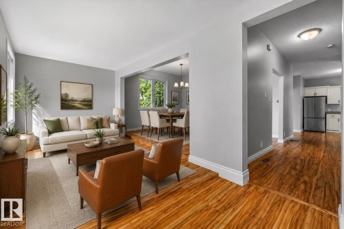 Wood-finish flooring throughout, bright recessed lighting, and a dining area with multiple windows - 11429 64 Street Nw, Edmonton, AB - Indoor Photo Showing Living Room