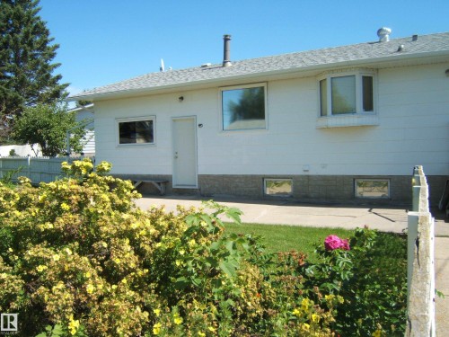 Exterior featuring white siding, a bay window, and a gray shingle roof - 5404 49 Street, Two Hills, AB - Outdoor