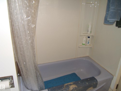 Alcove bathtub with shower surround and integrated shelving - 5404 49 Street, Two Hills, AB - Indoor Photo Showing Bathroom