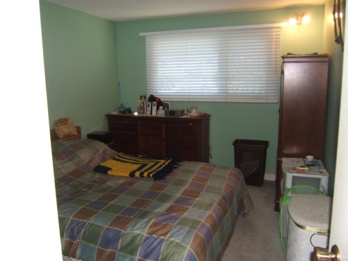 Window with horizontal blinds and wall-mounted lighting fixture - 5404 49 Street, Two Hills, AB - Indoor Photo Showing Bedroom