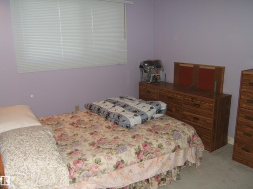 Wall-to-wall carpeting and a window with horizontal blinds - 5404 49 Street, Two Hills, AB - Indoor Photo Showing Bedroom