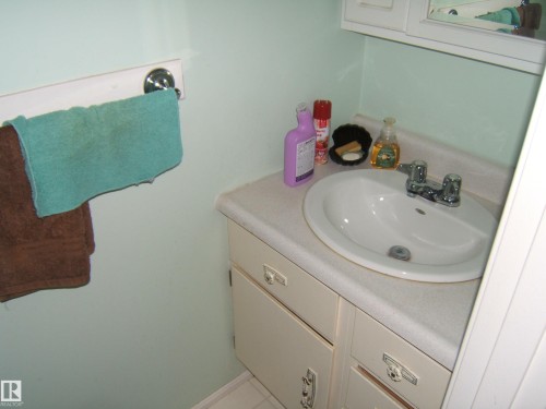 White vanity with an integrated sink and chrome faucet - 5404 49 Street, Two Hills, AB - Indoor Photo Showing Bathroom