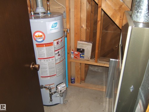 Water heater and furnace system with exposed wood framing - 5404 49 Street, Two Hills, AB - Indoor Photo Showing Basement