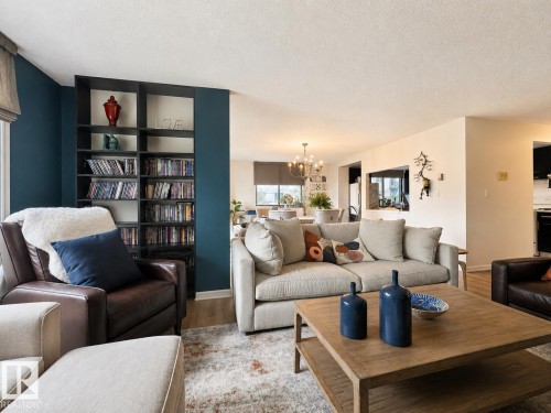 Living area with built-in shelving, wood-finish flooring, and a bright, open layout - #301 9808 103 St Nw, Edmonton, AB - Indoor Photo Showing Living Room