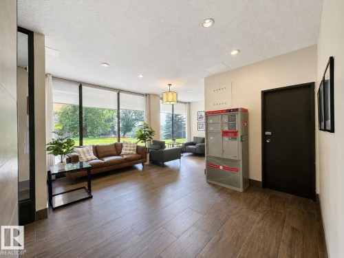 Lobby area featuring large windows, recessed lighting, and wood-finish tile flooring - #301 9808 103 St Nw, Edmonton, AB - Indoor Photo Showing Other Room