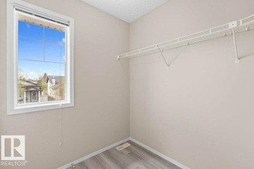 Bright room featuring a large window, neutral wall paint, and wood-finish flooring - 21344 88 Avenue Nw, Edmonton, AB - Indoor With Storage