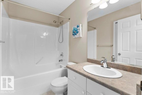 Bathroom featuring a white integrated tub and shower unit with a brushed nickel showerhead and faucet - 21344 88 Avenue Nw, Edmonton, AB - Indoor Photo Showing Bathroom