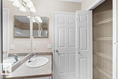 Bathroom vanity with integrated sink, chrome faucet, and expansive mirror - 21344 88 Avenue Nw, Edmonton, AB - Indoor Photo Showing Bathroom