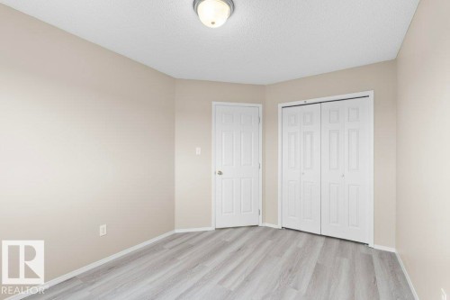 Room featuring wood-finish flooring, neutral wall paint, white trim, and a ceiling-mounted light fixture - 21344 88 Avenue Nw, Edmonton, AB - Indoor