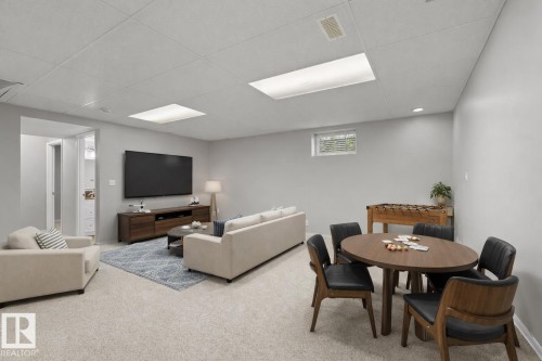 Carpeted recreation area featuring a drop ceiling with integrated lighting, a recessed window, and ample wall space - 21344 88 Avenue Nw, Edmonton, AB - Indoor