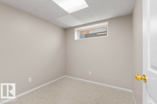 Neutral-toned wall space with light-colored carpeting, a drop ceiling, and a high horizontal window - 21344 88 Avenue Nw, Edmonton, AB - Indoor Photo Showing Other Room