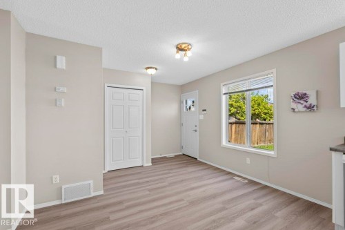 Entryway featuring wood-finish flooring, a white front door with decorative glass, and a large window overlooking a wooden privacy fence - 21344 88 Avenue Nw, Edmonton, AB - Indoor Photo Showing Other Room