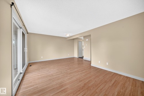 Open-concept room featuring wood-finish flooring, neutral wall tones, and recessed ceiling lighting - 6416 180 Street Nw, Edmonton, AB 