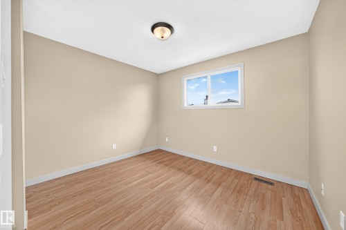 Wood-finish flooring, neutral wall tones, white trim, and a double-pane window - 6416 180 Street Nw, Edmonton, AB 