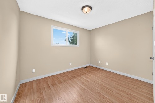 Wood-finish flooring, neutral wall tones, white trim, and a flush-mount ceiling light - 6416 180 Street Nw, Edmonton, AB 