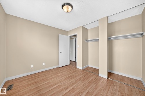 Wood-finish flooring, neutral wall tones, semi-flush mount ceiling fixture, and built-in closet shelving - 6416 180 Street Nw, Edmonton, AB 