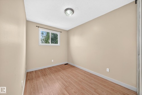 Neutral-toned walls, wood-finish flooring, and a flush-mount ceiling light - 6416 180 Street Nw, Edmonton, AB 