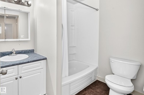 Bathroom featuring a white vanity with paneling, a single basin sink, and a dark countertop - 6416 180 Street Nw, Edmonton, AB 