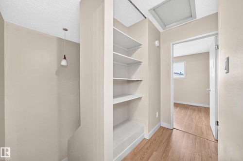 Built-in shelving, wood-finish flooring, recessed lighting, and a suspended pendant light fixture - 6416 180 Street Nw, Edmonton, AB 