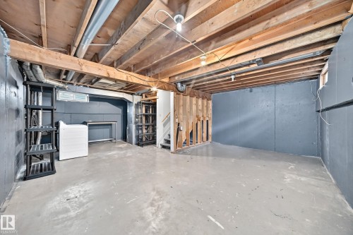 Unfinished basement with exposed wood joists, concrete flooring, and painted cinder block walls - 6416 180 Street Nw, Edmonton, AB 