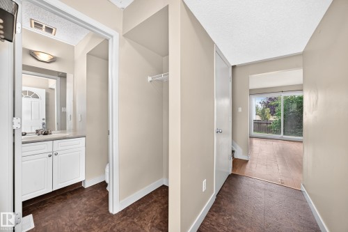 Entryway featuring a built-in closet with wire shelving, durable flooring, and a sliding glass door - 6416 180 Street Nw, Edmonton, AB 
