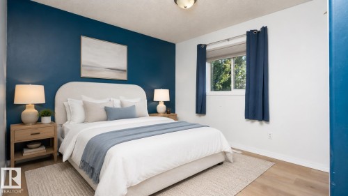 Neutral-toned wood-finish flooring, a bright window, and a bold accent wall - 1009 Macewan Close Sw, Edmonton, AB - Indoor Photo Showing Bedroom
