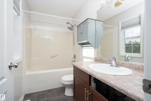 Full bathroom featuring a shower-tub combination, vanity with integrated sink, and window with blinds - 1009 Macewan Close Sw, Edmonton, AB - Indoor Photo Showing Bathroom
