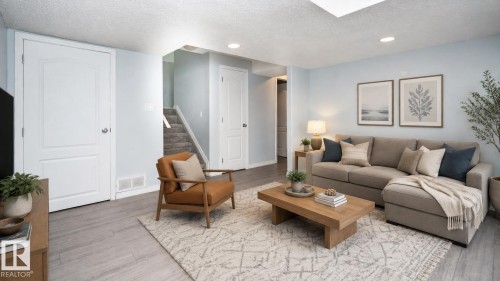 Recessed ceiling lighting, wood-finish flooring, staircase with carpeted treads, and paneled interior doors - 1009 Macewan Close Sw, Edmonton, AB - Indoor Photo Showing Living Room