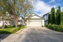 Exterior featuring an attached garage, a paved driveway, and established front landscaping - 1009 Macewan Close Sw, Edmonton, AB  - Outdoor With Facade 
