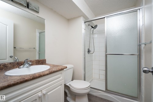 White vanity with a laminate countertop, chrome fixtures, and an oval undermount sink - 1009 Macewan Close Sw, Edmonton, AB - Indoor Photo Showing Bathroom