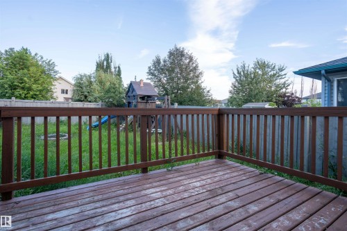 Wood-finish deck with railing overlooking a fenced yard - 1009 Macewan Close Sw, Edmonton, AB - Outdoor With Deck Patio Veranda With Exterior