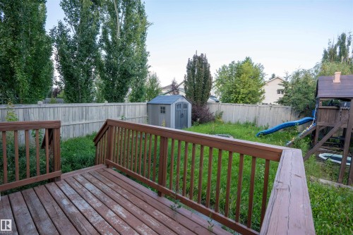 Wooden deck with railings, privacy fencing, and mature trees - 1009 Macewan Close Sw, Edmonton, AB - Outdoor With Deck Patio Veranda