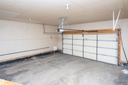 Concrete flooring, overhead garage door, built-in garage door opener, ceiling-mounted lighting - 