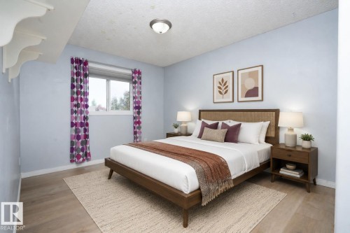 Light blue walls with wood-finish flooring - 1009 Macewan Close Sw, Edmonton, AB - Indoor Photo Showing Bedroom
