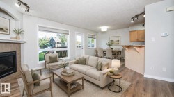 Living area featuring a fireplace with a tile surround, large window, and wood-finish flooring - 