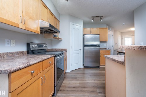 Light wood cabinetry with stainless steel hardware - 1009 Macewan Close Sw, Edmonton, AB - Indoor Photo Showing Kitchen