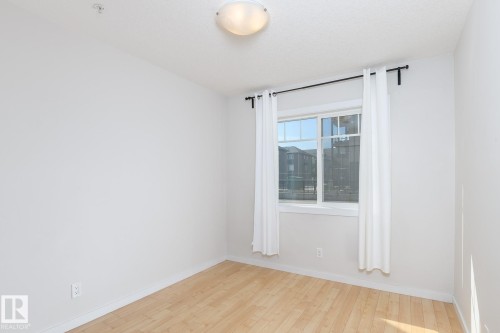 Recessed lighting, wood-finish flooring, and a flush mount ceiling light - #110 9523 160 Av Nw, Edmonton, AB - Indoor Photo Showing Other Room