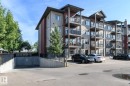 Multi-story building featuring balconies, stone accents, and a subterranean parking entrance - #110 9523 160 Av Nw, Edmonton, AB 