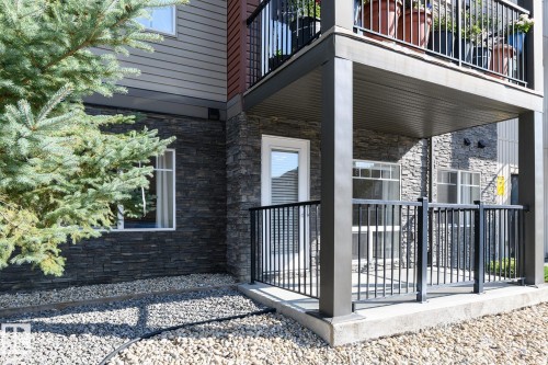 Stone veneer facade with horizontal siding accents - #110 9523 160 Av Nw, Edmonton, AB - Outdoor With Balcony With Exterior