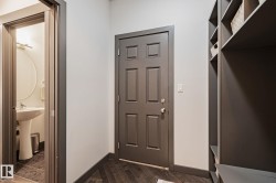 Entryway featuring a paneled door, built-in shelving, and wood-finish flooring - 