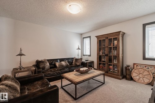 Carpeted flooring, recessed ceiling lighting, light neutral wall paint, and multiple windows with blinds - 1337 Secord Landing Nw, Edmonton, AB - Indoor Photo Showing Living Room