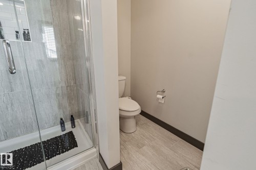 Glass-enclosed shower with gray tiled walls and a white base - 1337 Secord Landing Nw, Edmonton, AB - Indoor Photo Showing Bathroom
