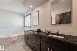 Dual vanity with dark wood-finish cabinetry and stone countertops - 