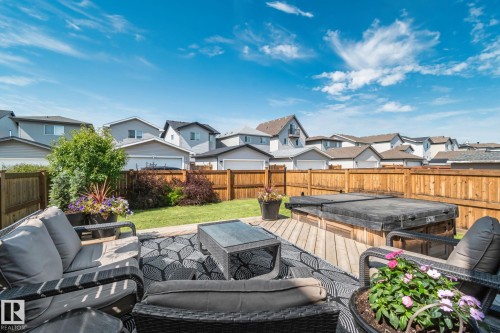 Backyard featuring a wood deck, built-in hot tub, and a manicured lawn - 1337 Secord Landing Nw, Edmonton, AB - Outdoor With Deck Patio Veranda