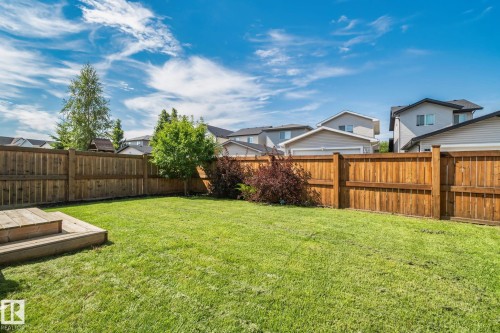 Expansive backyard featuring a manicured lawn, established shrubs, and a built-in wooden deck - 1337 Secord Landing Nw, Edmonton, AB - Outdoor