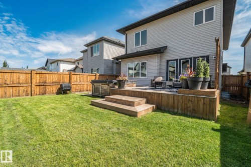 Expansive backyard featuring a manicured lawn, a wooden fence, and a multi-level wooden deck with steps - 1337 Secord Landing Nw, Edmonton, AB - Outdoor With Deck Patio Veranda
